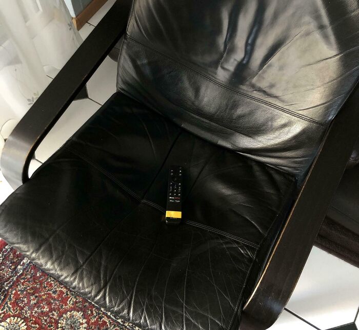 TV Remote With Yellow Duct Tape for Easy Spotting on Black Furniture