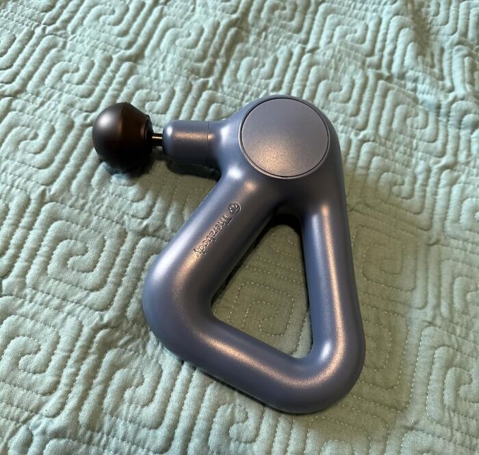 Your Muscles Are About To Get Their New BFF, The Handheld Percussion Massage Gun That Kicks Knot Butt