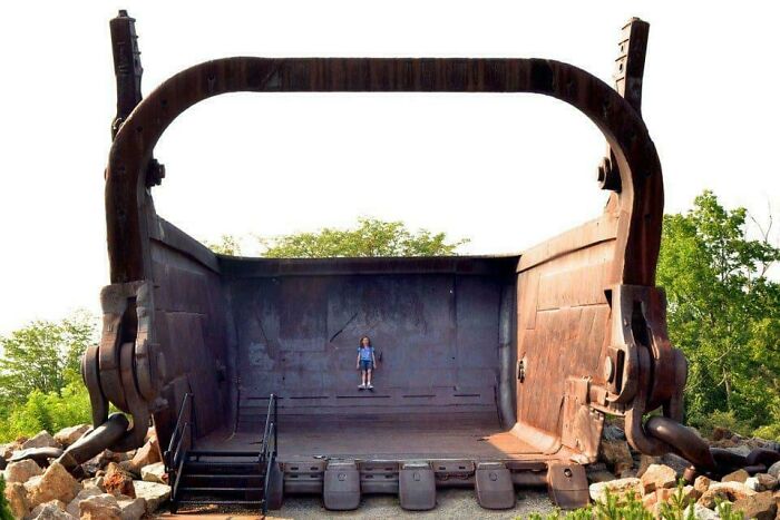 Tiny Girl Hanging Out Inside Giant Excavator Bucket