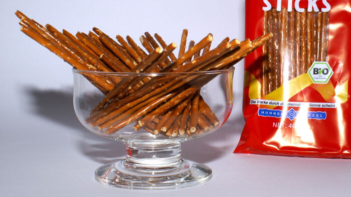 Mimicking adults by pretending pretzel sticks are cigarettes. The ultimate snack disguise.