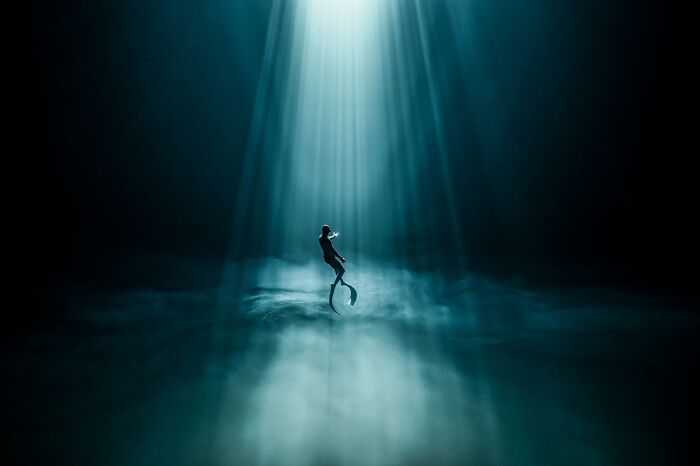Freediver Glides Through Sunlit Sulfur Clouds
