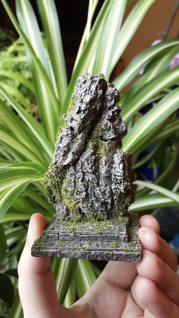 A Monolith Made From Tree Bark and Recycling Bin Junk