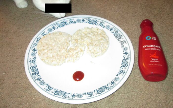 Stale Rice Cakes Dipped In Chili Sauce, Eaten On A Floor Next To A Curious Cat
