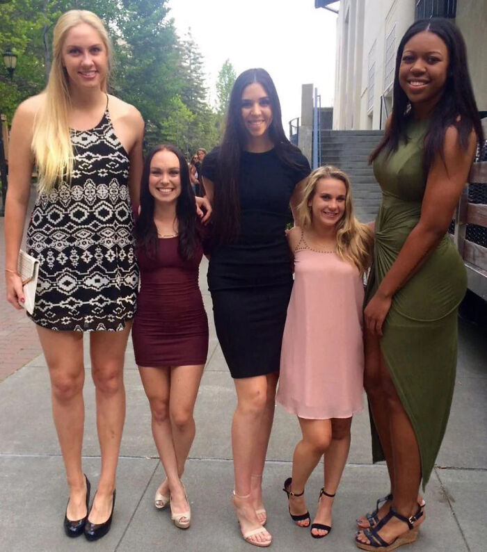 Basketball Players Standing Next to Cheerleaders – Size Confusion Alert!