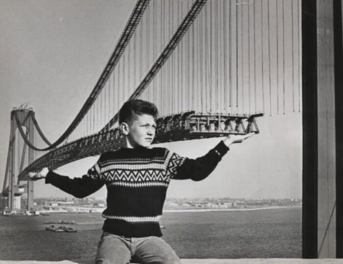 Kiddo Striking A Pose In Front Of A Giant Bridge Under Construction, 1963